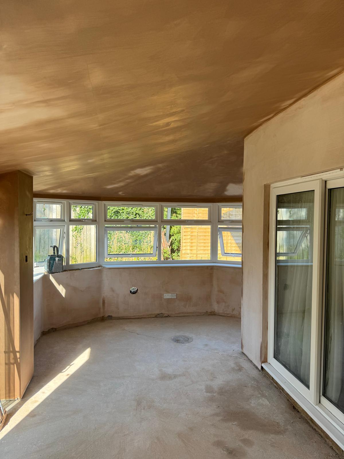 A bay-window room with skimmed walls and ceiling