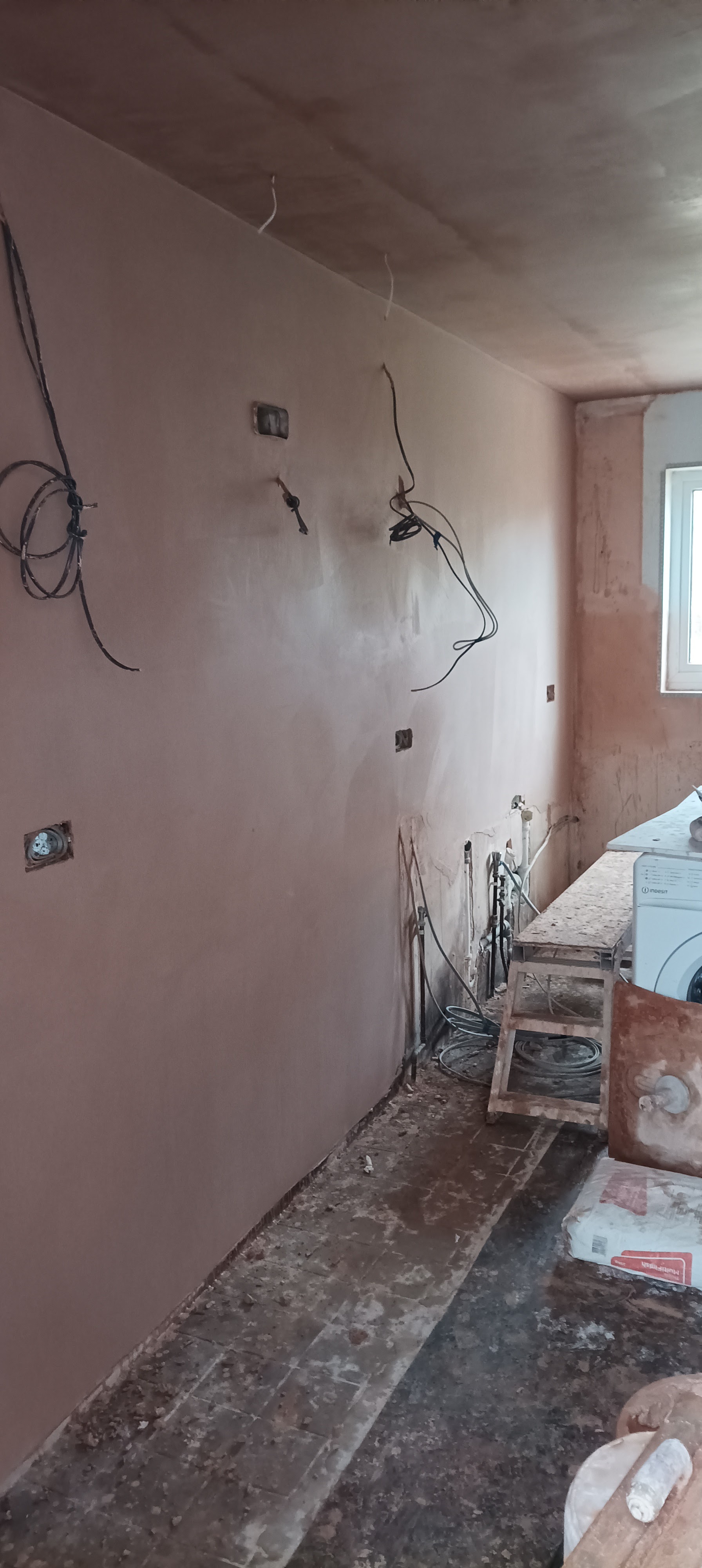 A long narrow room with new plaster on the walls