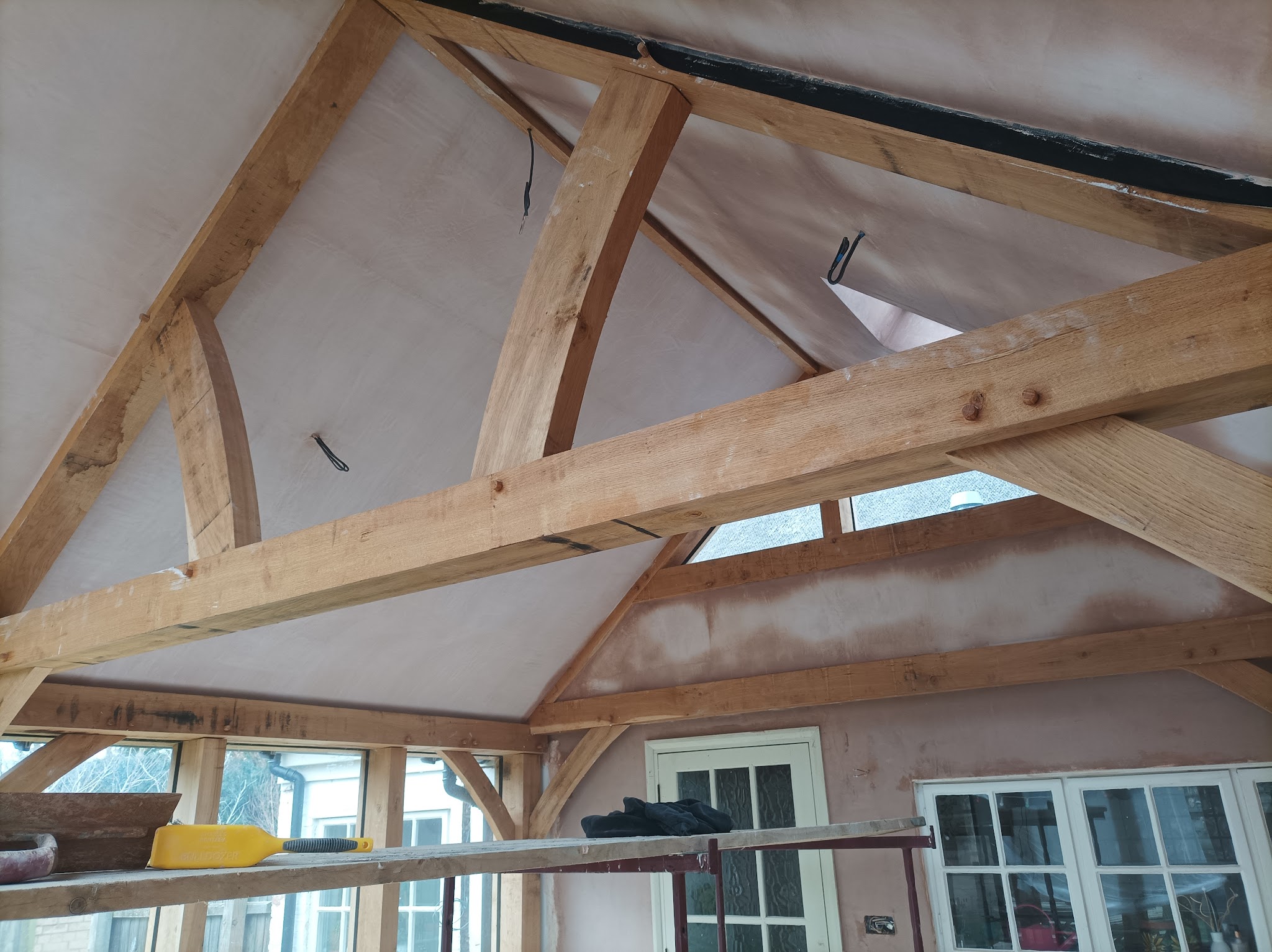 A vaulted ceiling with exposed oak beams, plastered between the timbers